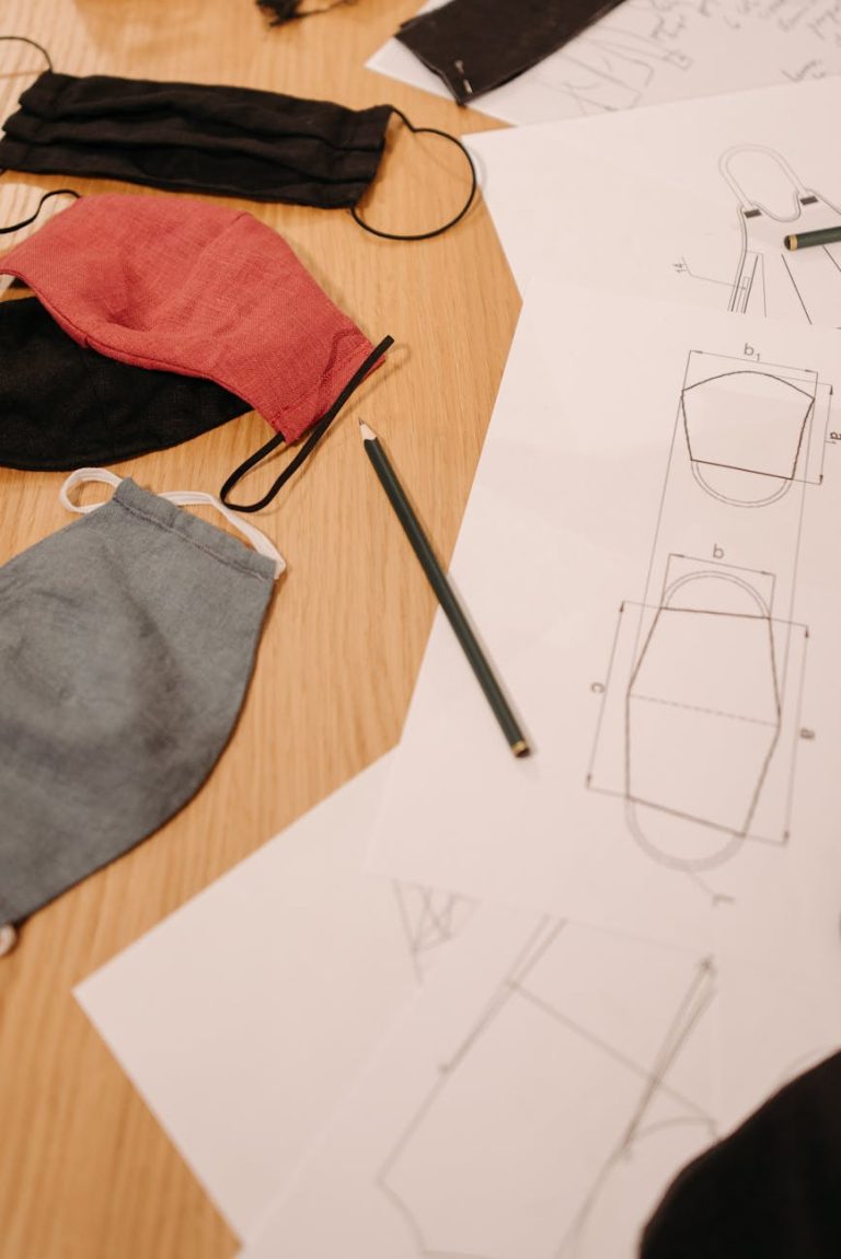 Top view of face mask patterns and sewing supplies on a wooden table.